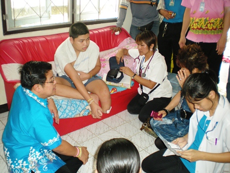 Deputy Mayor Verawat Khakhay (left) and Sub Lt. Supatra Ngamyanglai (right) discuss options with patient Supachai Komolthiti.